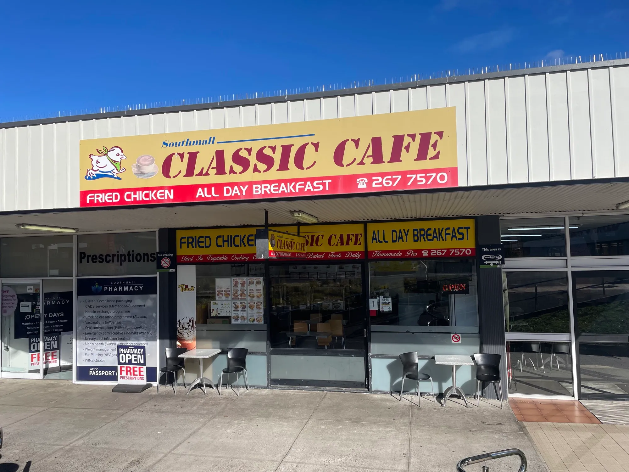 The Southmall Classic Cafe shopfront under a yellow and red sign reading "Fried Chicken" and "All Day Breakfast", with tables and chairs outside.