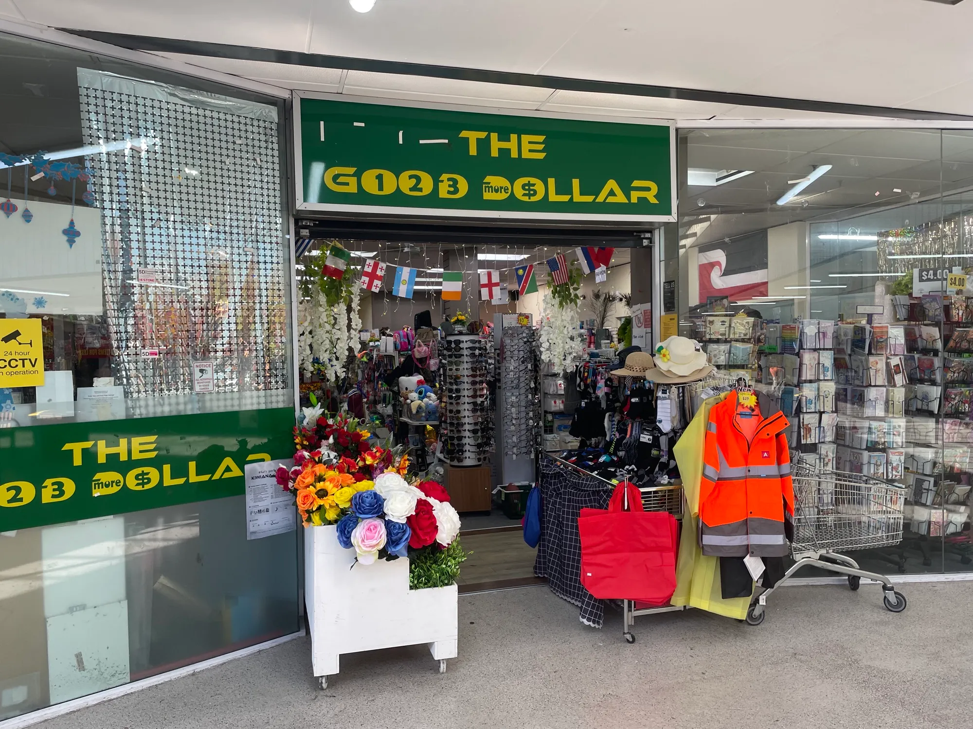 The Good 123 More Dollar shopfront inside Southmall, bunting flags strung across the open entrance and racks of clothing, hats and cards set out on the concourse.